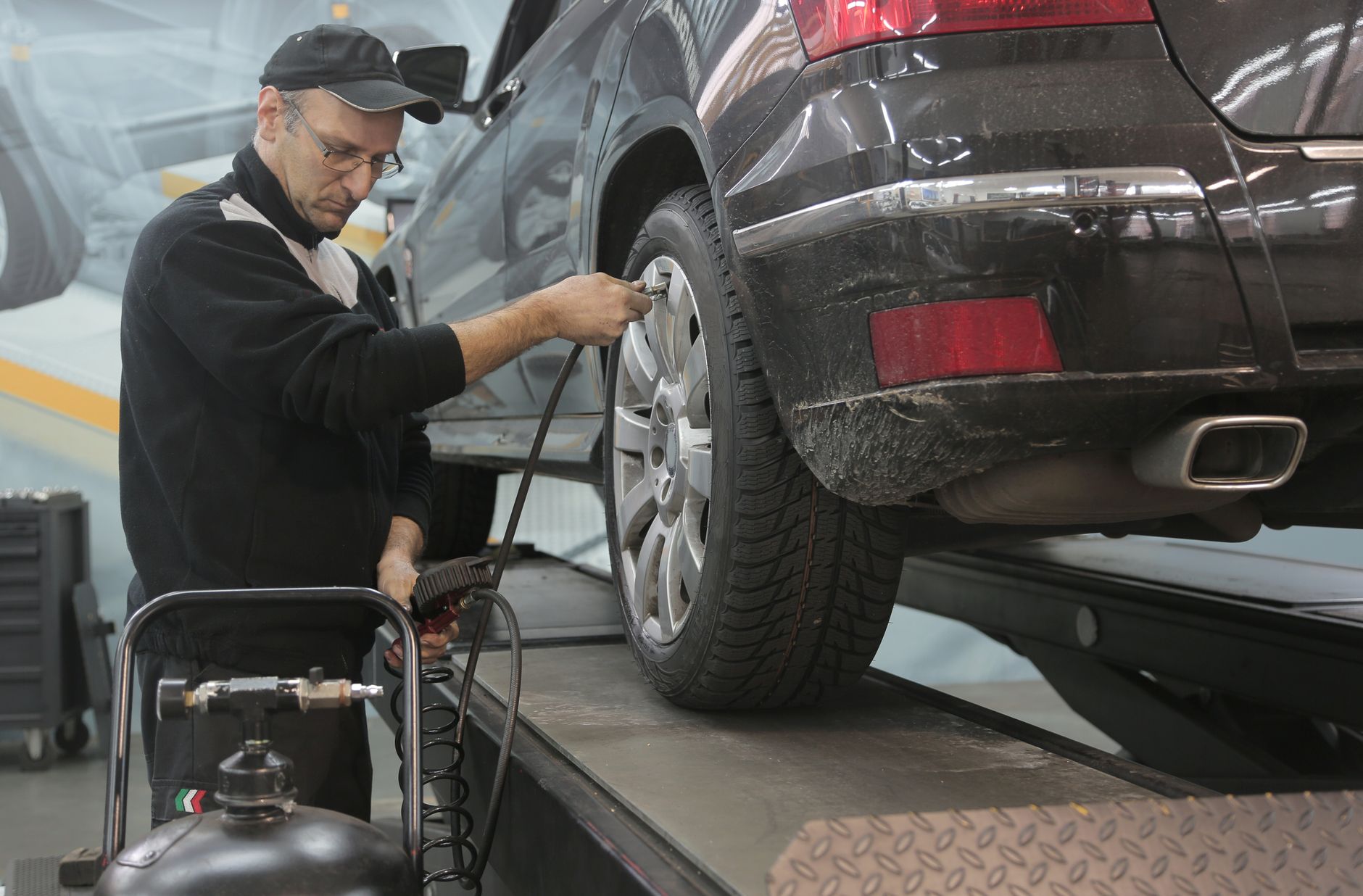 Mecánico comprobando la presión de un neumático de coche en un taller
